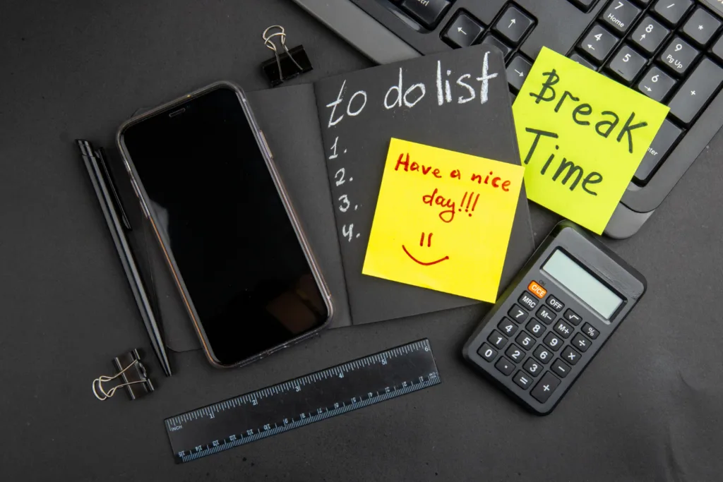 Productivity Hacks for a Balanced Life Image Credit: <a href="https://www.freepik.com/free-photo/top-view-break-time-have-nice-day-written-sticky-notes-list-black-notepad-phone-pen-calculator-ruler-binder-clips-keyboard-black-table_17188401.htm#fromView=search&page=1&position=2&uuid=14712d95-1397-4cfb-820b-b04b7b19d1ef">Image by KamranAydinov on Freepik</a>
